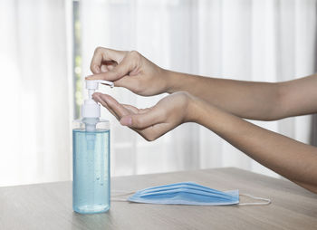 Close-up of woman holding glass jar on table