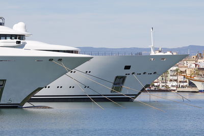 Boats moored at harbor against sky