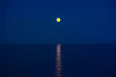 Scenic view of sea against clear blue sky at night