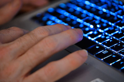 Cropped hand of man using laptop