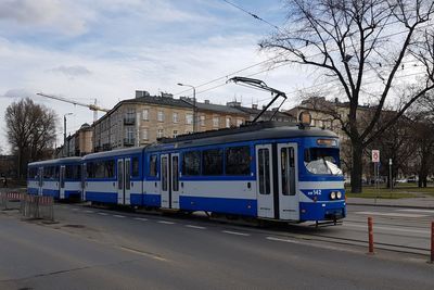 Train on railroad tracks in city against sky