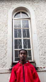 Portrait of man standing against wall