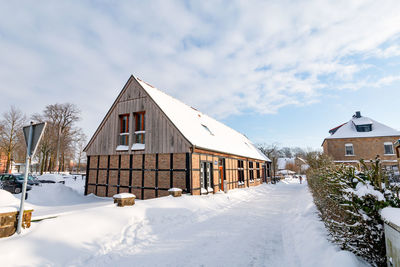 Snow covered houses and buildings against sky