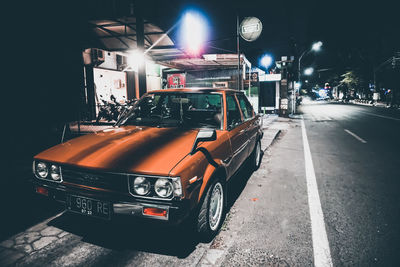 Cars on illuminated city street at night