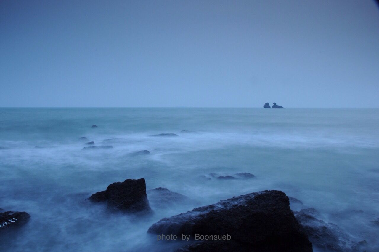 sea, water, scenics, beauty in nature, clear sky, tranquil scene, horizon over water, copy space, tranquility, blue, nature, idyllic, rock - object, wave, mountain, waterfront, seascape, outdoors, day, surf