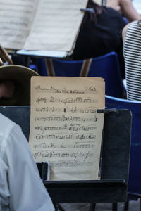 Midsection of man holding book while sitting on paper