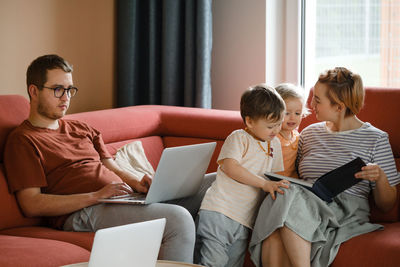 Big happy family watching movies playing games on laptop. mother father kids spending time with