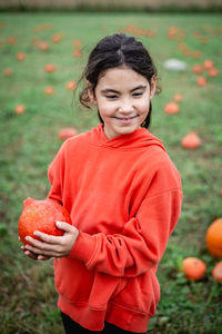 Portrait of cute girl holding pumpkin