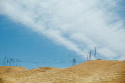 Low angle view of power lines against blue sky