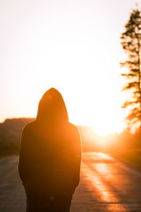 Rear view of silhouette man standing against sky during sunset