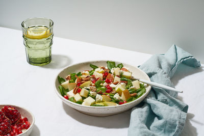 Fruits salad with nuts, balanced food, clean eating. spinach with apples, pecans and feta