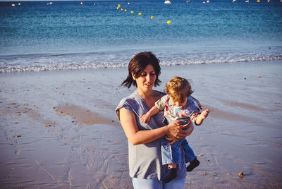 Woman holding child at beach