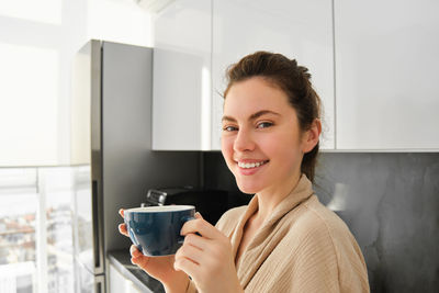 Young woman using mobile phone while sitting on table