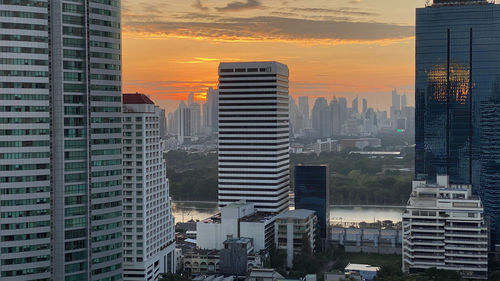 Modern buildings in  bangkok city against sky during sunset