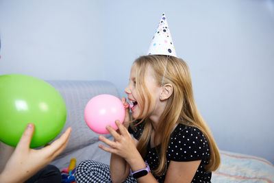 Children have fun playing, blowing up colorful balloons, at a birthday party
