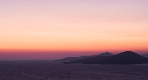 Scenic view of sea against romantic sky at sunset