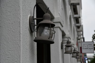 Low angle view of electric lamp hanging on wall