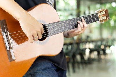 Midsection of man playing guitar