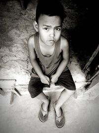 High angle portrait of boy sitting on floor