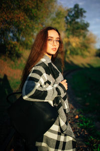 Autumn portrait of a young woman with glasses on nature