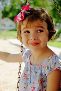 Girl on swing looking away at park