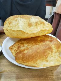 Close-up of hand holding bread on table