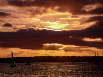 Scenic view of sea against dramatic sky during sunset