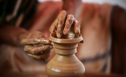 Midsection of potter making pot