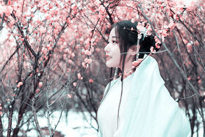 Young woman against cherry tree