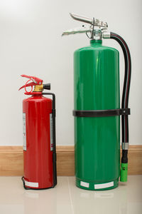 Close-up of fire extinguishers against wall
