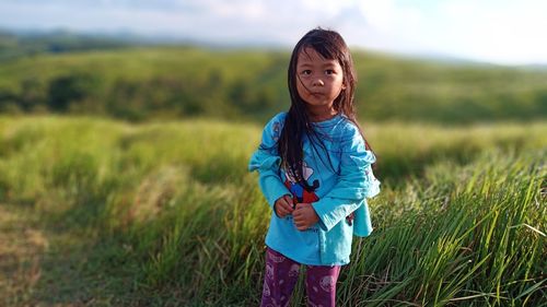 Portrait of girl standing on field