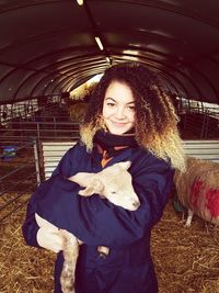 Portrait of young woman holding lamb