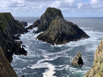 Scenic view of rocks in sea against sky