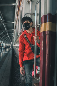 Man wearing sunglasses standing by train