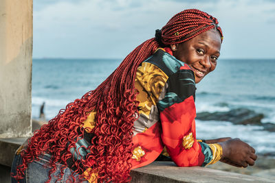 African woman with beautiful red rasta hair looking out over the sea from a balcony in accra ghana