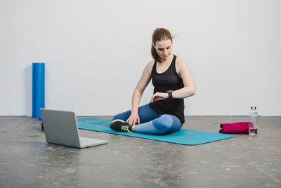 Full length of young woman using mobile phone