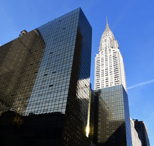 Low angle view of skyscrapers against blue sky