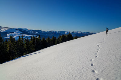 Scenic view of snowcapped mountains against clear blue sky