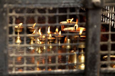 Close-up of illuminated candles in temple