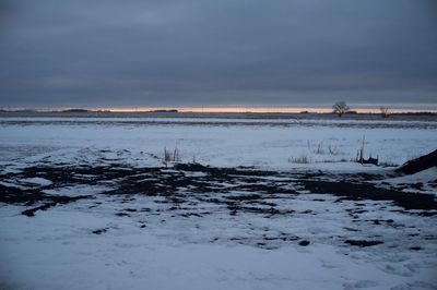 Scenic view of frozen lake against sky during sunset