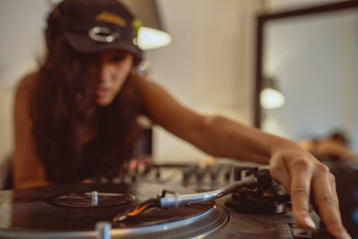 Close-up of fashionable young woman playing music at home