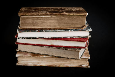 Close-up of books on table against black background