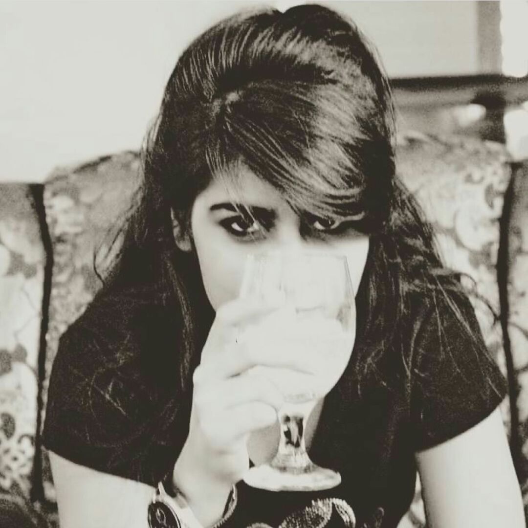 CLOSE-UP PORTRAIT OF YOUNG WOMAN STANDING AGAINST WALL