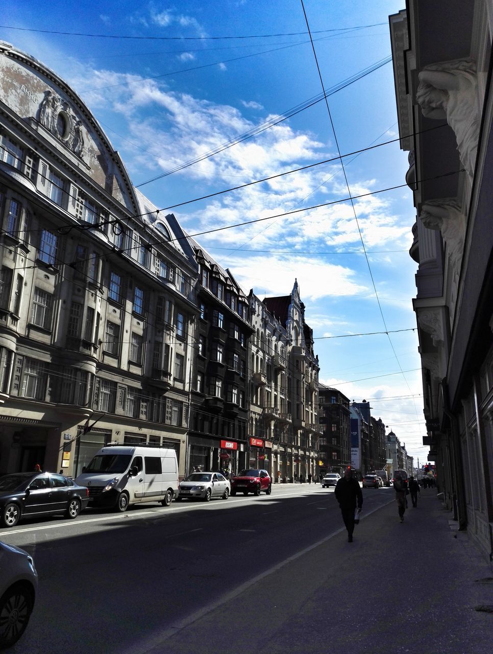 VEHICLES ON ROAD AGAINST BUILDINGS