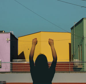 Low angle view of woman with arms raised