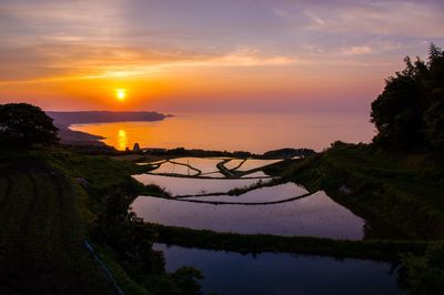 Scenic view of lake against sky during sunset