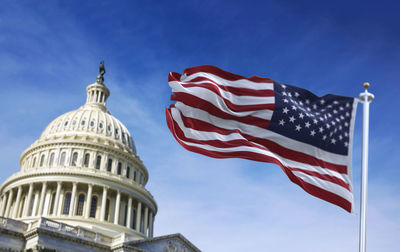 Low angle view of flag against blue sky