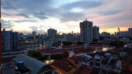 Illuminated cityscape against sky at dusk