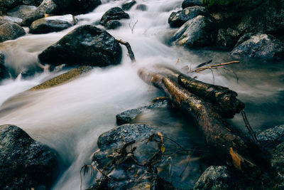 High angle view of stream flowing through rocks