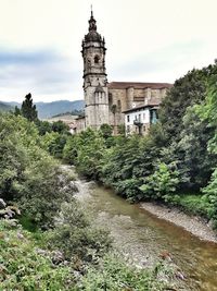 View of river by buildings against sky